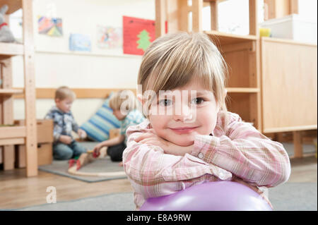 Porträt von lächelnden kleinen Mädchen mit verschränkten Armen Stockfoto