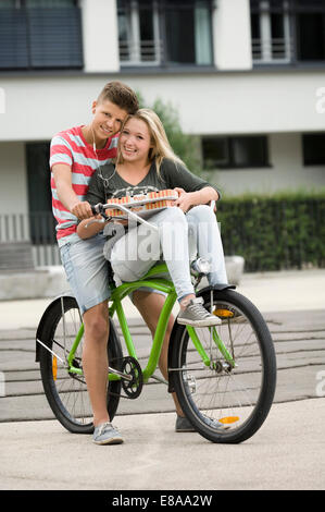 Porträt von Teenager-paar Musik hören mit dem Fahrrad, Lächeln Stockfoto