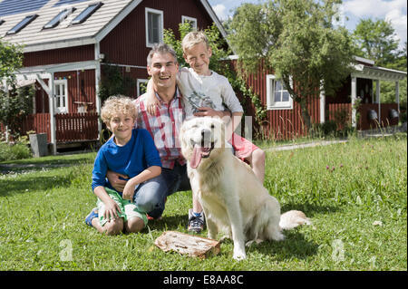 Junger Familienvater Söhne Hund Garten Stockfoto