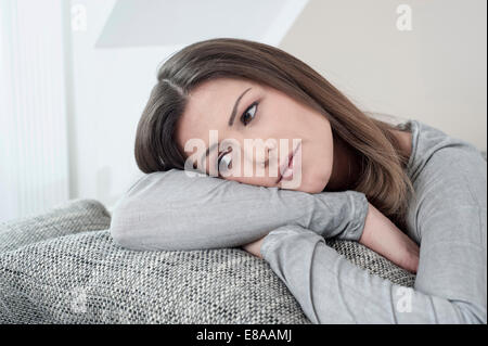 Porträt der nachdenkliche junge Frau auf Couch zu Hause Stockfoto