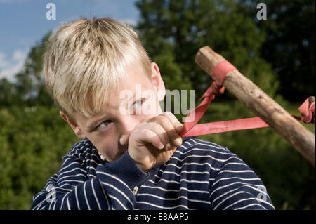 Porträt-Knaben halten handgemachte hölzerne Schleuder Stockfoto