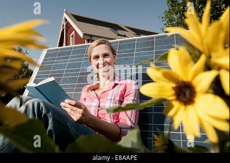 Frau, stützte sich auf Solar-Panel Buch Stockfoto