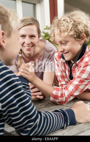 Brüder jungen Armdrücken Mutter beobachten Stockfoto