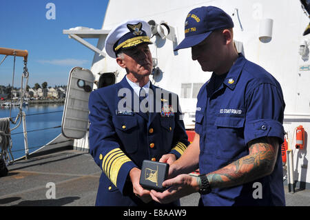 Kommandant der US Coast Guard Admiral Paul Zukunft Links, erkennt Petty Officer 2. Klasse Matthew Baasch, Recht, zugewiesen t Stockfoto