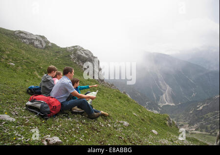 Vater und Kinder Wandern Berge Karte betrachten Stockfoto