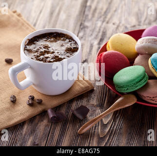 Tasse heißen Kakao und französische Macaron auf einem alten Holztisch. Stockfoto