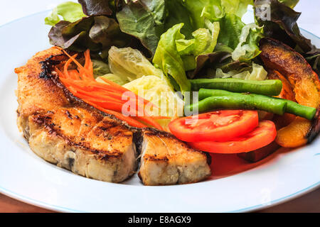 Gegrilltes Lachssteak mit verschiedenem Gemüse auf weißen Teller Stockfoto