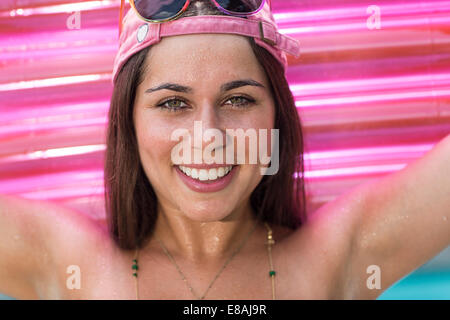 Porträt der jungen Frau hält Rosa Luftbett Stockfoto