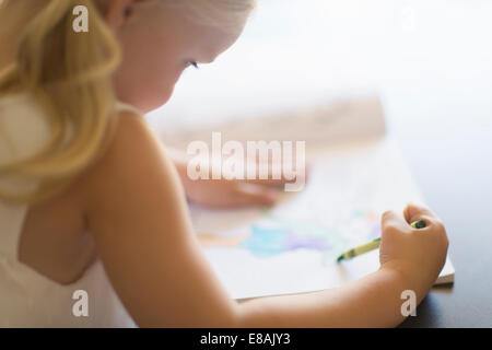 Schulter-Blick über Mädchen Färbung in Buch mit Buntstiften Stockfoto