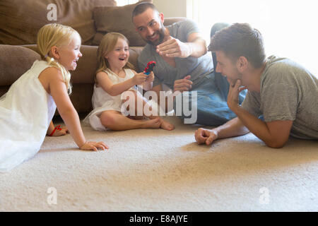 Männlichen Partner und zwei Töchter spielen im Wohnzimmer Stock Stockfoto