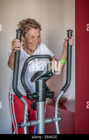 Eine sehr erfahrene Frau mit einem Heimtrainer Stockfoto