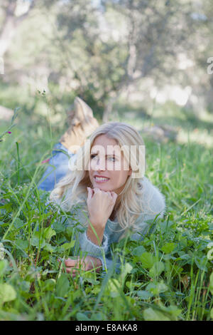 Frau liegt auf dem Rasen im Garten Stockfoto