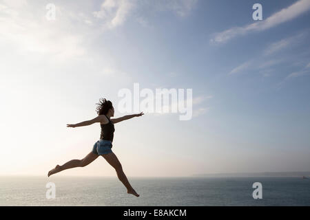 Frau gegen Skyline springen Stockfoto