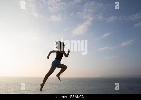 Frau gegen Skyline springen Stockfoto