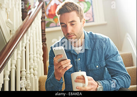 Mann mit Smartphone auf Treppe Stockfoto