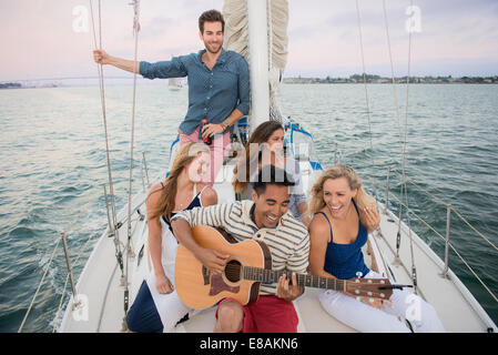 Freunde auf Segelboot, Mann Gitarre spielen Stockfoto