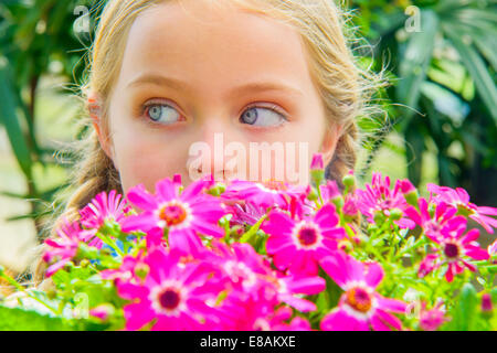 Porträt eines Mädchens Blick seitwärts hinter rosa Blüten Nahaufnahme Stockfoto