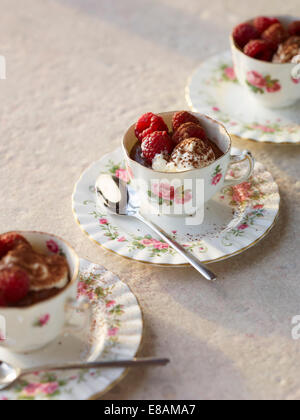 Schokoladenmousse mit Himbeeren und Sahne in Vintage Teetassen Stockfoto