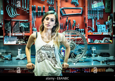 Porträt der jungen weiblichen Mechaniker in Motorradwerkstatt Stockfoto