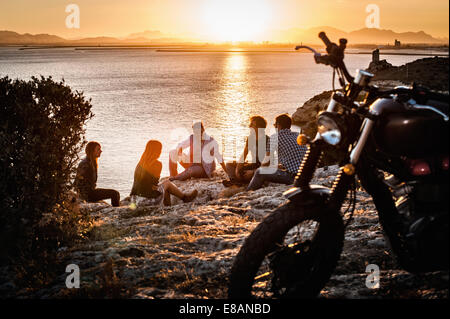 Fünf Motorrad-Freunde eine Pause an der Küste bei Sonnenuntergang, Cagliari, Sardinien, Italien Stockfoto