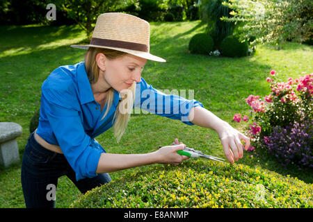 Mitte Erwachsene Frau Schnitt perfekte Absicherung im Garten Stockfoto