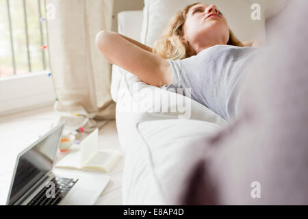 Frau liegt auf dem Sofa Tagträumen Stockfoto