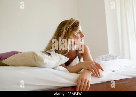 Frau liegend im Bett Tagträumen Stockfoto