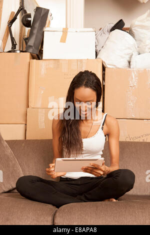 Frau sitzt in Wohnung, umgeben von Feldern Stockfoto