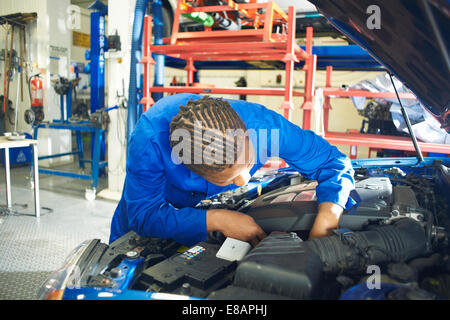 Männliche Student der Suche im Automotor in Garage Werkstatt Stockfoto