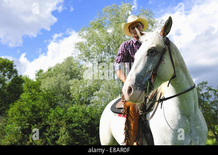 Niedrigen Winkel Porträt des jungen Mann im Gang der Cowboy auf Pferd Stockfoto