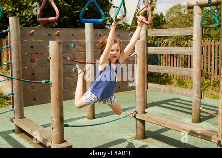 Mädchen energetisch auf Schaukel auf dem Spielplatz spielen Stockfoto