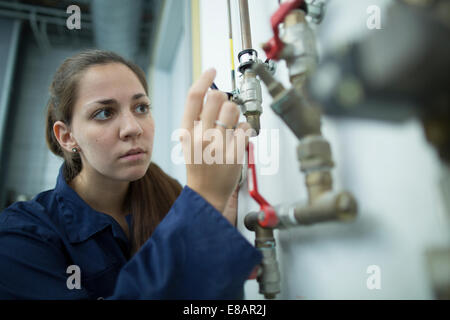 Ingenieurin drehen Rohr Ventil in Fabrik Stockfoto