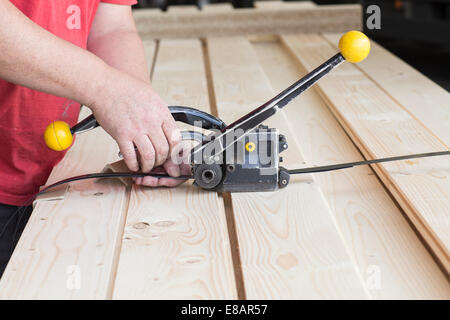 Nahaufnahme eines männlichen Lagerarbeiter Befestigung Holzbohlen im Baumarkt Stockfoto