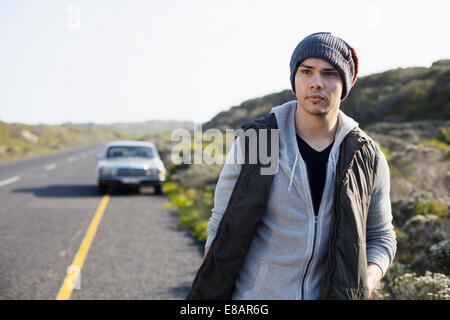 Junger Mann zu Fuß entlang Road, Cape Town, Western Cape, Südafrika Stockfoto