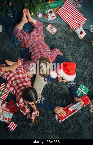 Vater auf Wohnzimmer Boden Eröffnung Weihnachtsgeschenke mit Tochter und Sohn Stockfoto