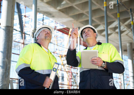 Bauleiter und Builder nachschlagen auf Baustelle Stockfoto