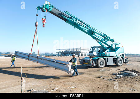 Zwei Bauherren Führung Träger am Kran auf Baustelle Stockfoto