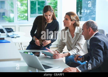 Drei Unternehmerinnen und Unternehmer mit informellen Treffen in Büro Stockfoto