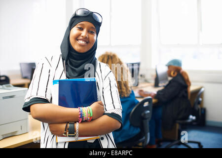 Porträt der jungen Studentin mit Datei in College-Klasse Stockfoto