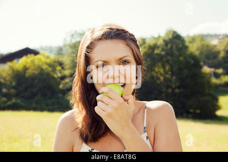 Junge Frau beißende Apfel Stockfoto