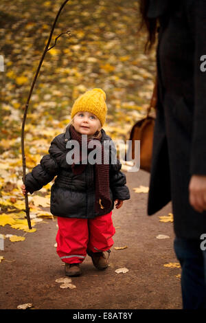 Junges Mädchen auf Spaziergang tragen Winterkleidung, hält Stock Stockfoto