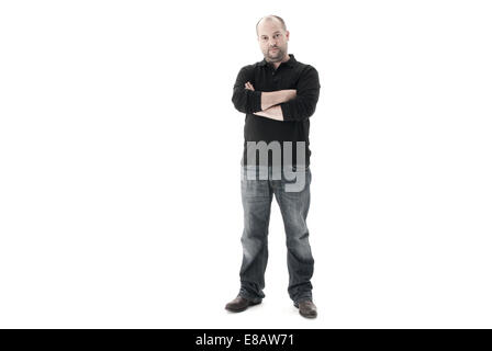 Voller Länge Schuss eines jeden Tag Menschen in Jeans mit verschränkten Armen und einem schwarzen Ausdruck in die Kamera schaut Stockfoto