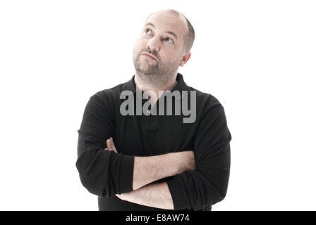 Mitte Schuss von einem Mann mit verschränkten Armen nachschlagen und denken Schuss vor einem weißen Hintergrund in einem Studio tragen ein schwarzes top Stockfoto