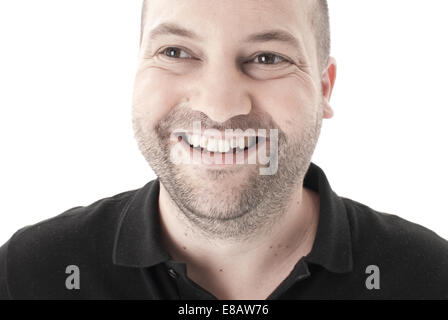 Nahaufnahme Bild eines Mannes mit Stoppeln lächelnd und Blick von der Kamera entfernt, vor einem weißen Hintergrund erschossen Stockfoto