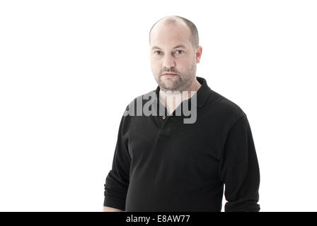 Mitte Schuss eines durchschnittlichen Mannes in ein schwarzes Top mit zurückweichenden Haaren und Stoppeln, Blick in die Kamera mit kein Ausdruck Stockfoto