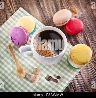 Tasse Kaffee und französische Macarons auf einem alten Holztisch. Stockfoto
