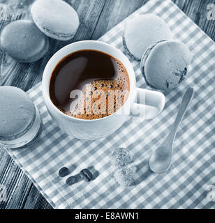 Tasse Kaffee und französische Macaron auf einem alten Holztisch. Stockfoto