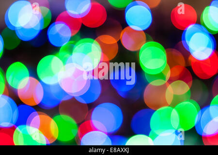 Erstellt durch eine Reihe von hellen mehrfarbigen Bokeh Hintergrund unscharf gestellt Weihnachtsbeleuchtung. Stockfoto