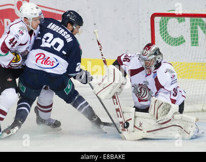 Zagreb, Kroatien. 3. Oktober 2014. Matthew Anderson von Medvescak Zagreb (C) schießt den Puck gegen Torwart Jakub Sedlacek von Dinamo Riga (R) während ihres Spiels bei Kontinental Hockey League (KHL) in Zagreb, Hauptstadt Kroatiens, 3. Oktober 2014. Medvescak gewann 3-2. © Miso Lisanin/Xinhua/Alamy Live-Nachrichten Stockfoto