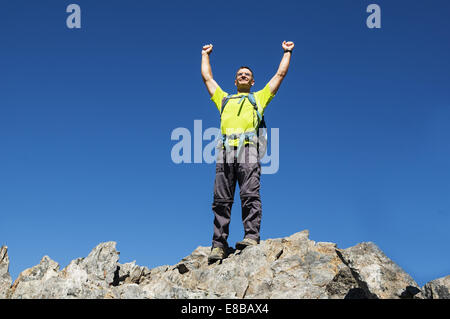 Mann feiert seinen Erfolg auf dem Gipfel des Hurd durch die Erhöhung seiner Fäuste Stockfoto